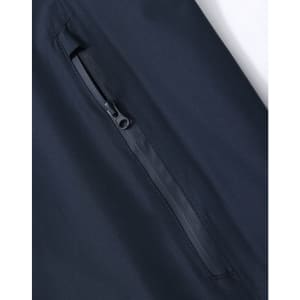 A close-up of a navy waterproof jacket showing a zippered pocket, with a sleek, modern design and a logo.