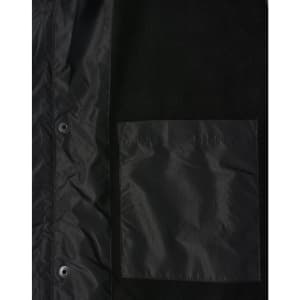 A unisex black jacket featuring a straightforward design and a chest pocket, with a small logo displayed.