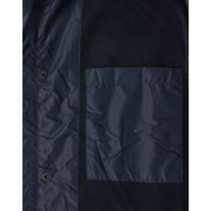 A navy unisex jacket featuring a pocket and snap buttons, made from a mix of materials. It has a logo.