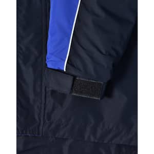 A close-up of a navy jacket featuring blue and white detailing, with a Velcro cuff closure. It has a logo on it.