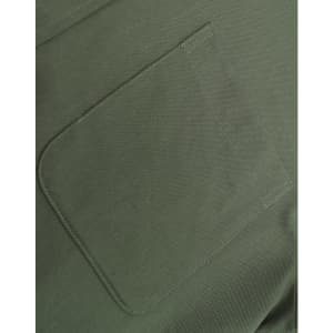 A close-up of a green cotton blend fabric featuring a stitched pocket.