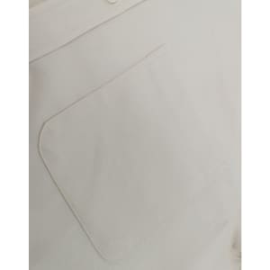 A close-up of a light-coloured cotton blend shirt featuring a back pocket and a button detail.