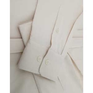 A men's smart casual long-sleeve shirt in a light cream colour, featuring buttoned cuffs and a soft cotton blend fabric.
