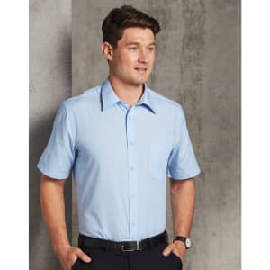 A short sleeve button-up shirt in light blue with subtle pin stripes and a chest pocket, worn by a man.