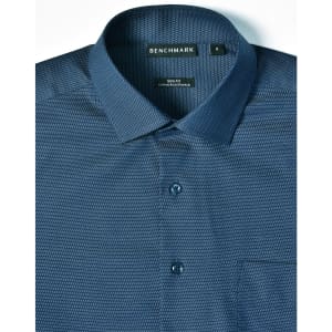 A blue pin dot button-up shirt with a slim fit design, featuring a collar and pocket. It has a branding label.