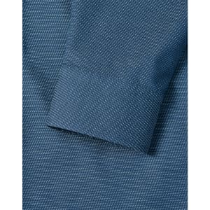 A detailed close-up of a blue men's button-up shirt featuring a pin dot pattern and a cuff.