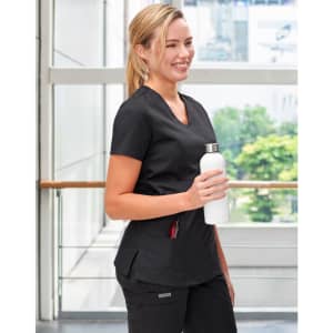 Black ladies' scrub top with a V-neck and pockets, held by a smiling woman holding a white drink bottle.