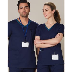 A navy scrub top with contrasting teal collar details, worn by a male and female model. Features pockets and identification badges.