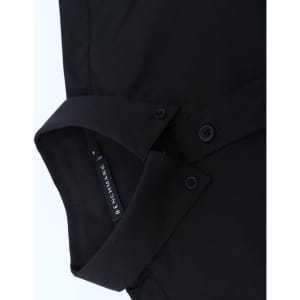 A black cotton blend long-sleeve shirt with a collar and button details, featuring a logo tag.