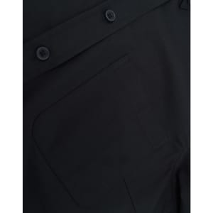 A close-up of a black cotton blend shirt featuring buttons and a pocket detail.