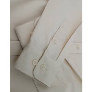 A light beige cotton blend long-sleeve shirt featuring buttoned cuffs and a smooth fabric texture.
