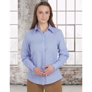 A woman models a blue and white gingham check button-up shirt with long sleeves in a bright indoor setting.