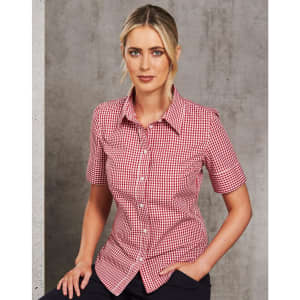 A red and white gingham short-sleeved button-up shirt worn by a model, featuring a branded logo.