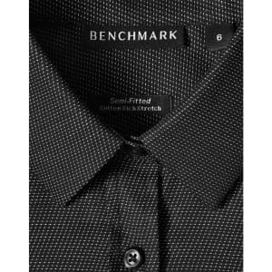 A black ladies' button-up shirt with a pin dot pattern, featuring a collar and a logo label.