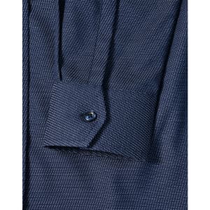 A navy blue pin dot stretch long sleeve shirt with a buttoned cuff and a branded logo.