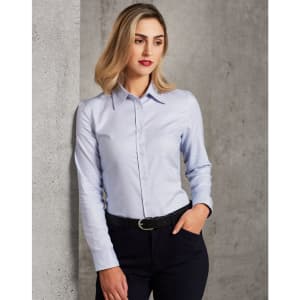 A long-sleeve button-up shirt in light blue, featuring a collar and a fitted design, paired with dark trousers.