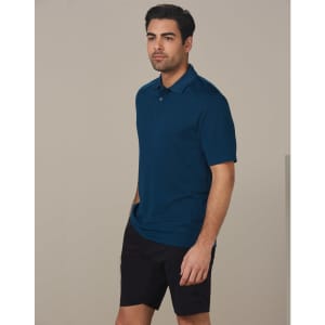 A man wearing a dark teal polo shirt and black cargo shorts, standing against a plain background.