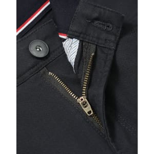 A close-up of the zipper and button detail on a pair of black flexi chino pants, featuring a branded label.
