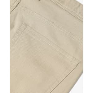 A close-up of beige chino pants, featuring a pocket and textured fabric details. The pants have a logo on them.