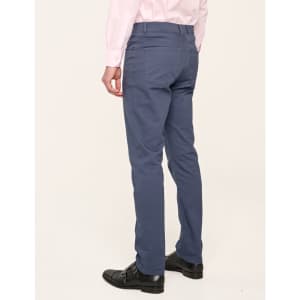 Men's blue jean style flexi chino pants displayed from the back, paired with a light pink shirt and black shoes.