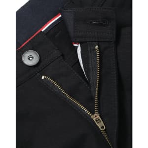 A close-up of black ladies' chino pants, featuring a zip fly, button closure, and a branded label.