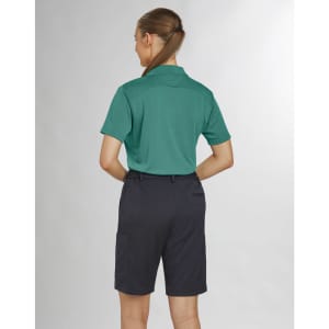 A woman in a green polo shirt and black utility cargo shorts, viewed from the back. The shorts have pockets and are knee-length.