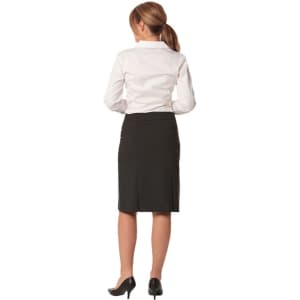 A black wool stretch pleated skirt, seen from the back, paired with a white shirt and heeled shoes.