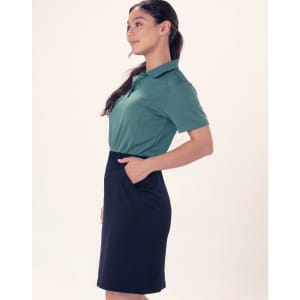A ladies' utility cargo skirt in navy, featuring pockets and styled with a green polo shirt.
