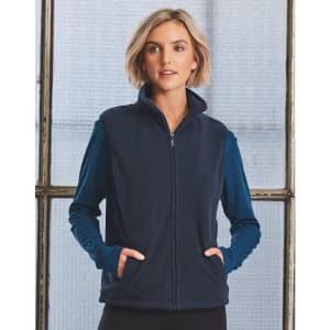 A unisex polar fleece vest in navy, featuring a zip front and side pockets. The model is wearing a long-sleeve top underneath.