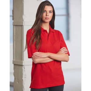 A red unisex traditional polo shirt features a collar and short sleeves, displayed on a model in a bright setting.