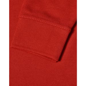 A close-up of a red long sleeve polo shirt, featuring a ribbed cuff and textured fabric.