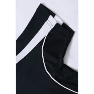 A black polo shirt featuring white accents and a logo at the collar. The fabric appears textured.