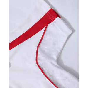 A kids' short-sleeve polo in white with red accents and a logo. Features breathable fabric for comfort.
