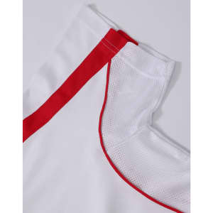 A white polo shirt with red accents and mesh detailing on the collar and shoulder. Features a logo.