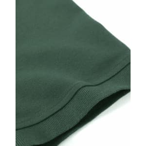 A close-up of a dark green cotton stretch polo shirt, featuring a neat hem and smooth texture.