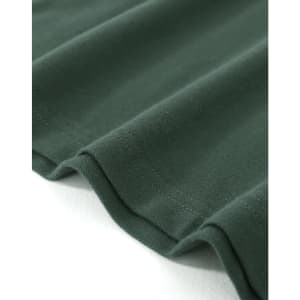 A close-up of a dark green cotton stretch polo shirt, showcasing the fabric's texture and the hem.