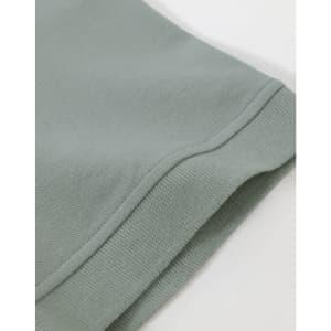 A close-up of the hem of a men's cotton stretch polo in a soft green colour, featuring a knitted cuff.