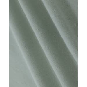 A close-up of light green cotton fabric with a smooth texture, showcasing fine weaves and folds.