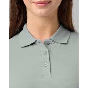 A close-up of a woman's light grey cotton stretch polo shirt with a collared neck and three buttons.