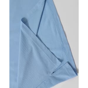 A light blue polo shirt featuring a folded sleeve, with a subtle branding logo.