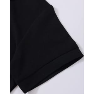 A close-up of a black polo shirt sleeve featuring a folded cuff and a subtle branding logo.