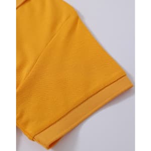 A close-up of a yellow polo shirt sleeve with a textured fabric and cuff detail. The shirt has a logo.