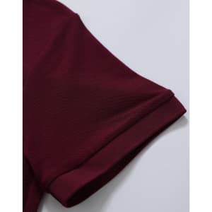 A maroon polo shirt featuring a classic pique texture and a logo on the sleeve.