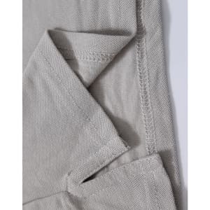 A close-up of a light grey polo shirt, showing the textured fabric and stitching details. The shirt features a logo.