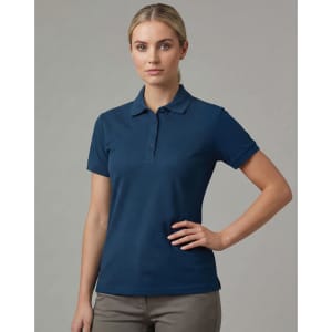 A navy blue ladies ultrafine cotton pique polo with a collar and short sleeves. The model is posing with hands on her hips.