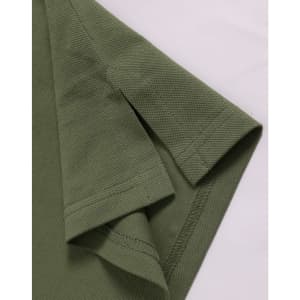 A close-up of a green ultrafine cotton pique polo shirt, highlighting the sleeve and fabric texture.