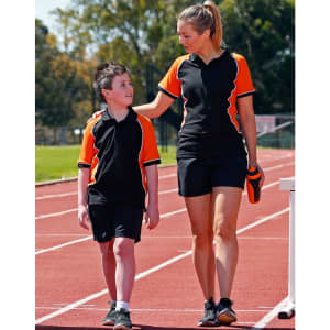 A black and orange tri-colour polo shirt worn by a woman and a boy, standing on a running track.
