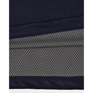 A close-up of a navy and charcoal polo shirt, featuring a textured fabric and a logo.