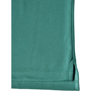 A close-up view of a teal men's bamboo charcoal polo shirt, featuring a hem with side splits and a logo.