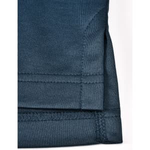 A dark teal men's sustainable poly/cotton polo shirt, showcased with a focus on the hem and sleeve detailing.